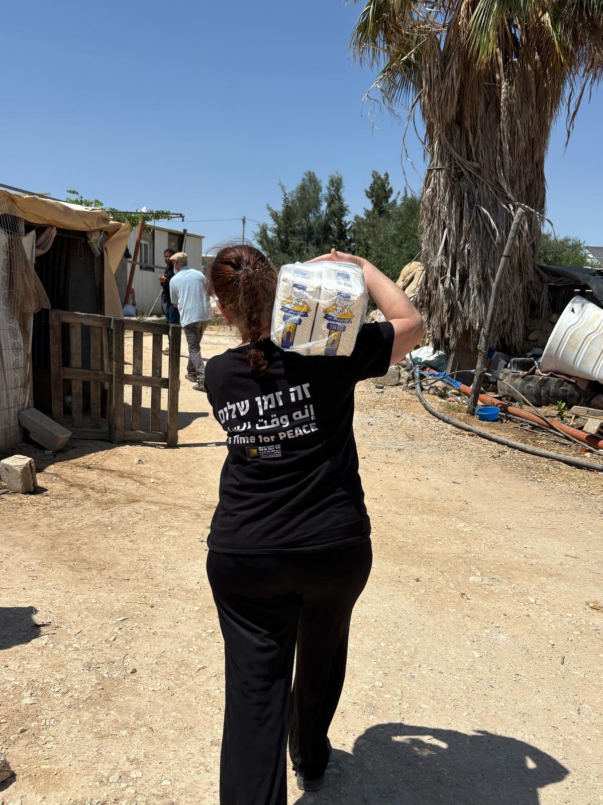 A Parents Circle member carries a Ramadan food package towards a home in a West Bank village.